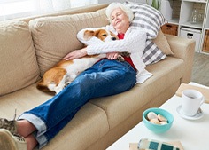 A woman resting with a corgi