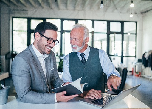 A senior businessman working with a younger one