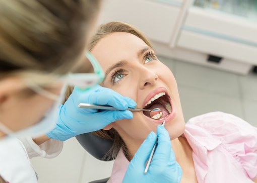 Dentist checking patient's tooth-colored fillings after treatment