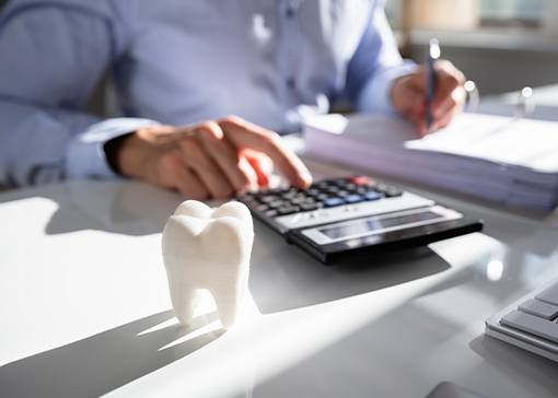 Man calculating the cost of dental emergencies