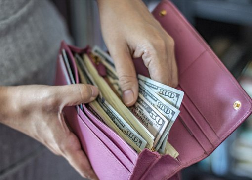 Woman holding wallet of cash