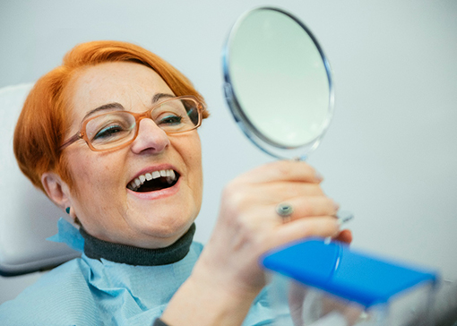 A woman admiring her dentures in North Andover