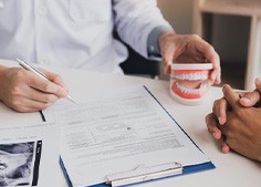 Dentist and patient reviewing dental insurance forms