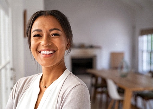 Woman with healthy teeth smiling at home