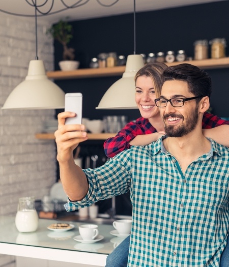 Man and woman with healthy smiles taking a selfie together