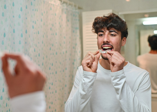 a man putting a mouthguard in before bed
