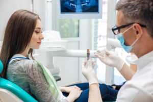 Dentist consulting young woman about a dental implant.